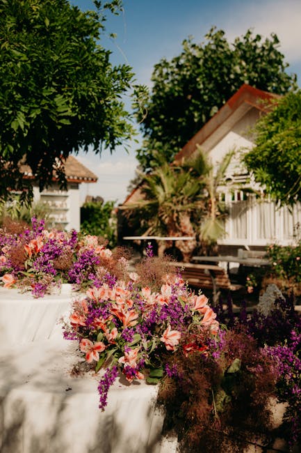Lush garden view with vibrant flowers and quaint bungalows on a sunny summer day.